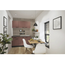 Kompakte Küche mit Küchenschränken, Esstisch und Stühlen in einem hellen Raum.