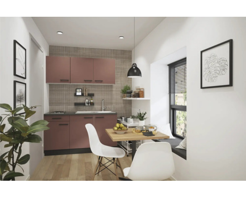 Kompakte Küche mit Küchenschränken, Esstisch und Stühlen in einem hellen Raum.