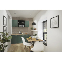 Cuisine avec armoires vertes, plans de travail en bois, table à manger et chaises dans une pièce lumineuse.