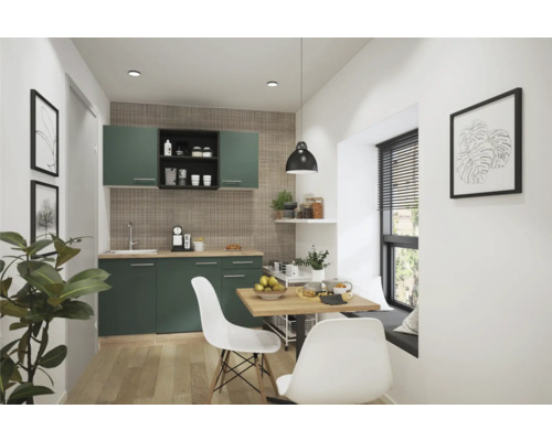 Cuisine avec armoires vertes, plans de travail en bois, table à manger et chaises dans une pièce lumineuse.