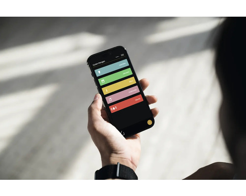Person hält Smartphone mit Smart Home App