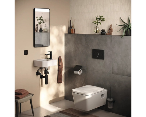 Salle de bains avec WC suspendu, lavabo, miroir et accessoires