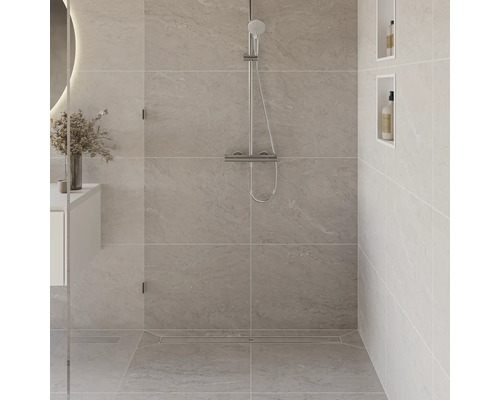 Douche carrelée avec robinetterie de douche et étagères murales.