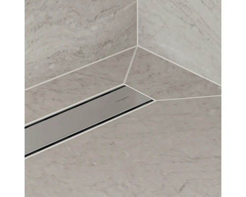 Caniveau de douche en acier inoxydable intégré dans un sol de salle de bain carrelé.