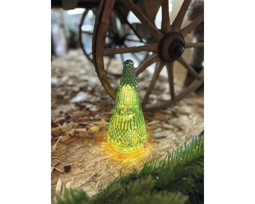 Dekorativer Glasbaum mit Beleuchtung und Holzrad im Hintergrund