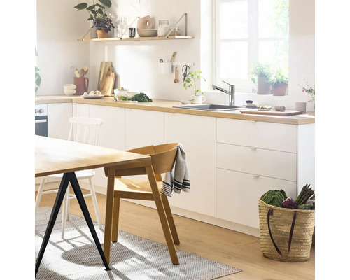 Cuisine claire avec table à manger, chaises et ustensiles de cuisine