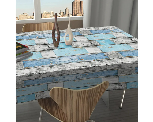 Tisch mit Tischdecke im Holzdesign in einem hellen Raum.