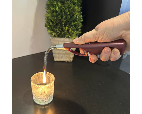 Main allumant une bougie avec un briquet à manche