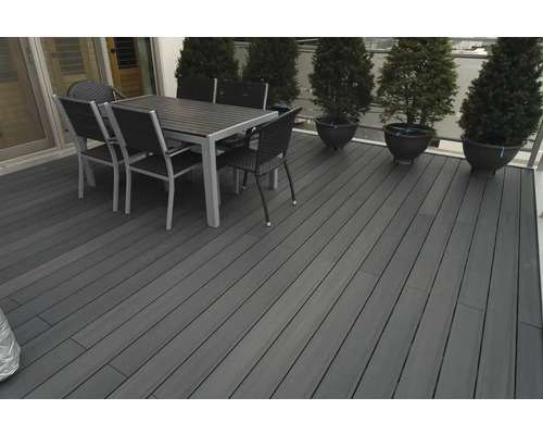 Terrasse mit Terrassendielen, Esstisch und Stühlen im Aussenbereich.