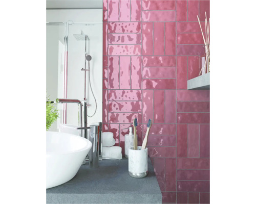 Salle de bain avec lavabo, douche et carrelage mural aspect brique