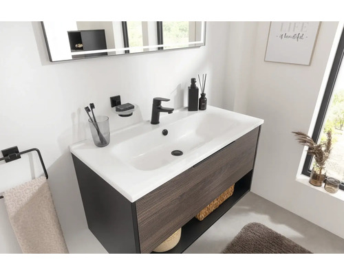 Meuble-lavabo avec meuble sous-vasque, robinet, miroir et accessoires de salle de bain dans une salle de bain