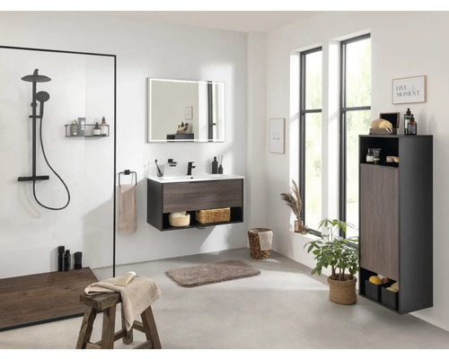 Helles Badezimmer mit Dusche, Waschtisch, Spiegel, Hochschrank und Dekorationen für eine freundliche Atmosphäre.