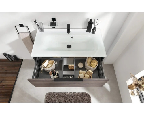 Badezimmer mit Waschbeckenunterschrank, Waschbecken, Armatur, Handtuchhalter und Badaccessoires.