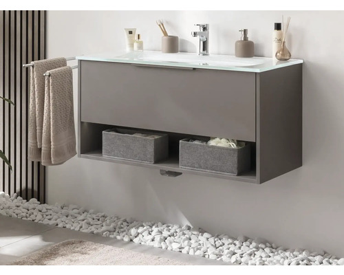 Meuble sous-vasque gris avec serviettes et compartiments de rangement dans une salle de bain