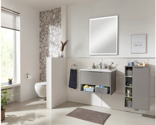 Salle de bain lumineuse avec meuble sous-lavabo, miroir, toilettes et meubles de rangement pour une ambiance organisée.