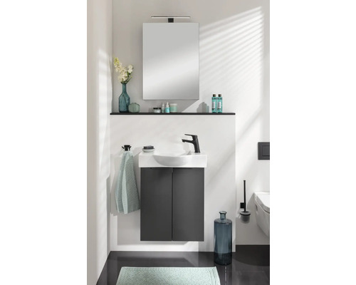 Salle de bain moderne avec lavabo, armoire de toilette et accessoires.