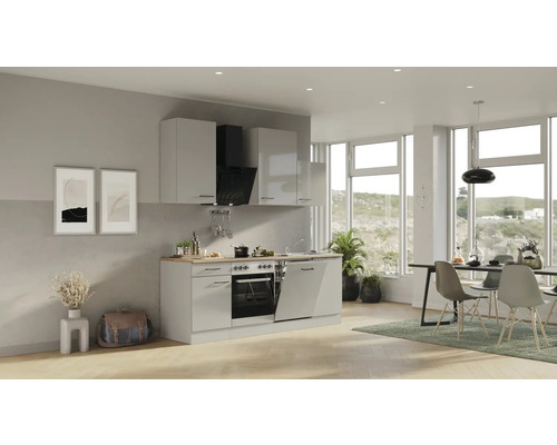 Espace de vie lumineux avec kitchenette, table à manger et chaises.