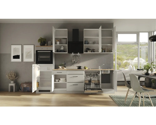 Cuisine claire avec armoires encastrées, lave-vaisselle, réfrigérateur et hotte.