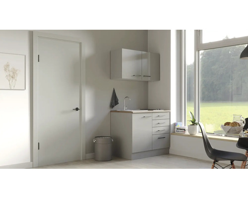 Heller Waschraum mit Waschbecken, Unterschrank und Hängeschrank unter einem großen Fenster.