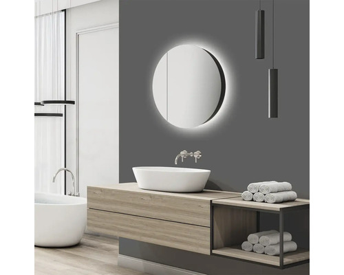 Modernes Badezimmer mit rundem Spiegelschrank, Waschtisch und Badewanne.