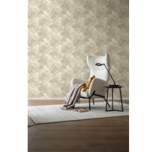 Wohnzimmer mit beiger Tapete mit Palmenmuster, Sessel und Beistelltisch.