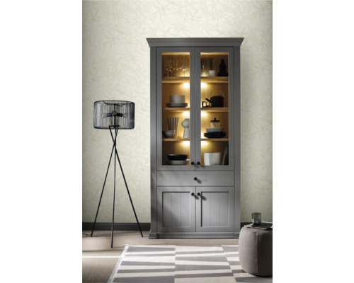 Wohnszene mit grauem Vitrinenschrank, Stehlampe und Teppich