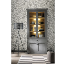 Wohnzimmer mit grauem Vitrinenschrank, Stehlampe und gemusterter Tapete.