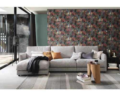 Wohnzimmer mit grauer Couch, gemusterter Tapete und dekorativen Elementen für eine gemütliche Atmosphäre.