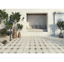 Terrasse avec décoration : coin salon, plantes en pot et carreaux de sol de style vintage.