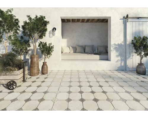 Terrasse avec décoration : coin salon, plantes en pot et carreaux de sol de style vintage.