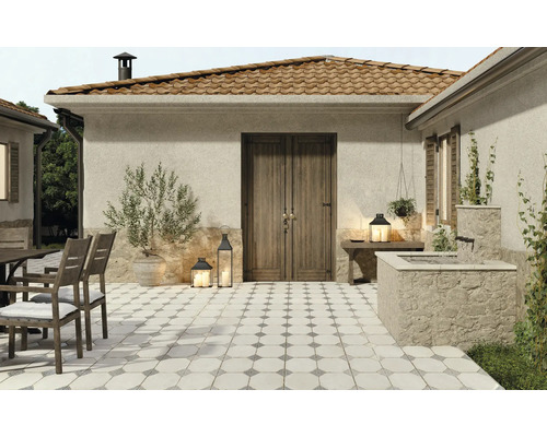 Espace extérieur avec des carreaux de sol de style méditerranéen, des meubles de jardin et des éléments décoratifs.