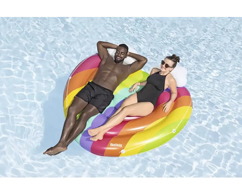 Deux personnes se détendent sur un îlot de piscine gonflable multicolore dans l''eau.