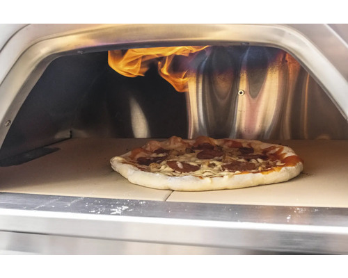 Pizza im Pizzaofen mit Flammen.