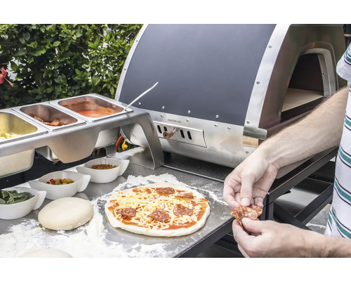 Zubereitung einer Pizza mit Zutaten und Pizzaofen