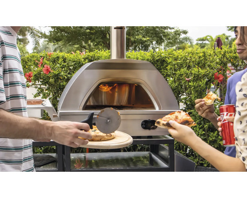 Edelstahl Pizzaofen mit Personen beim Pizzaschneiden und Essen im Freien