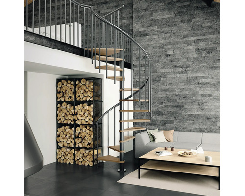 Wohnzimmer mit Wendeltreppe aus Holz und Metall, Brennholzregal und Sofa