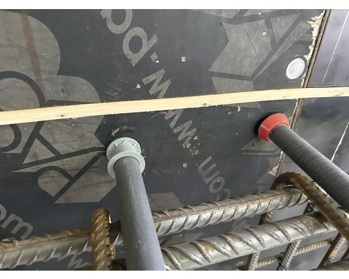 Nahaufnahme von Abstandhaltern zwischen Bewehrung und Schalung