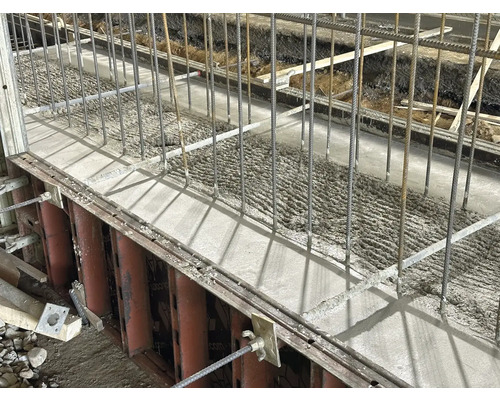 Frisch gegossener Beton mit Bewehrungsstahl in einer Schalung.
