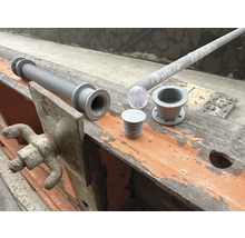 Accessoires pour béton tels qu''un vibrateur à béton monotube, un corps d''évidement et un élément de lanterneau transparent sur un chantier de construction.