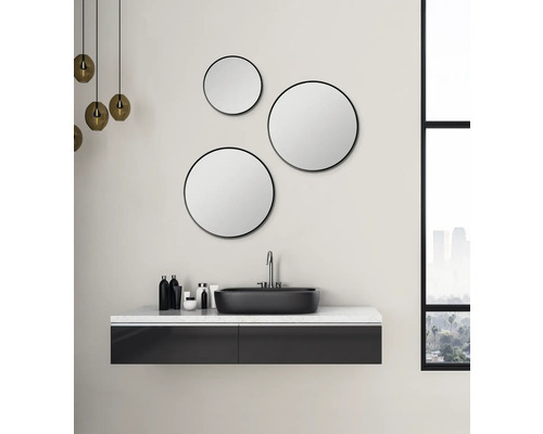 Salle de bain moderne avec miroirs ronds, lavabo et éclairage.