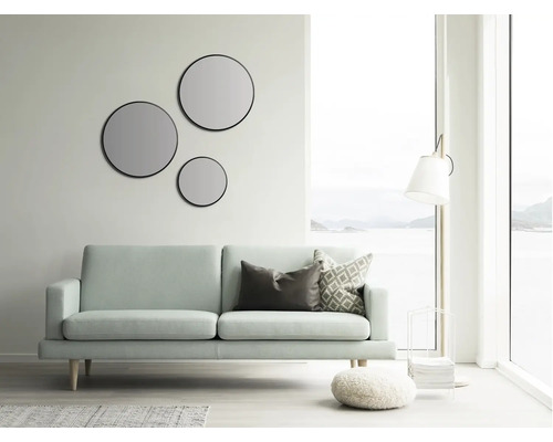 Salon lumineux avec canapé, miroirs ronds et lampadaire