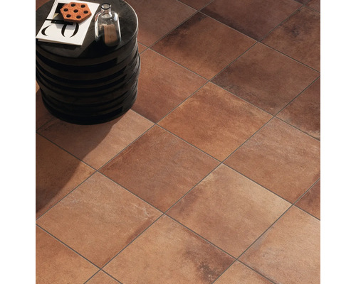 Bodenansicht mit quadratischen Terrakottafliesen und einem kleinen Beistelltisch