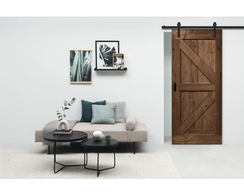 Wohnzimmer mit Sofa, Couchtischen, Wandbildern und Holztür mit Schiebesystem