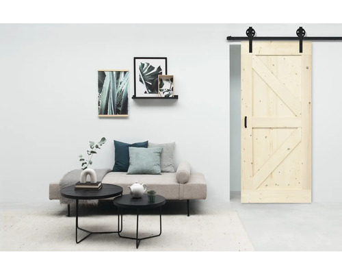 Wohnzimmer mit Schiebetür aus Holz, Couch und Deko-Elementen.