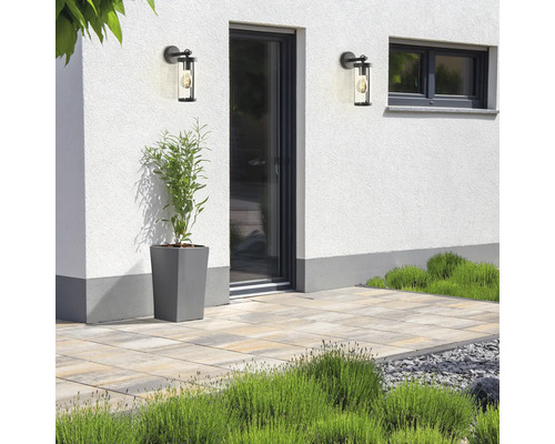 Außenaufnahme mit zwei Wandleuchten, Pflanze und Steinplatten