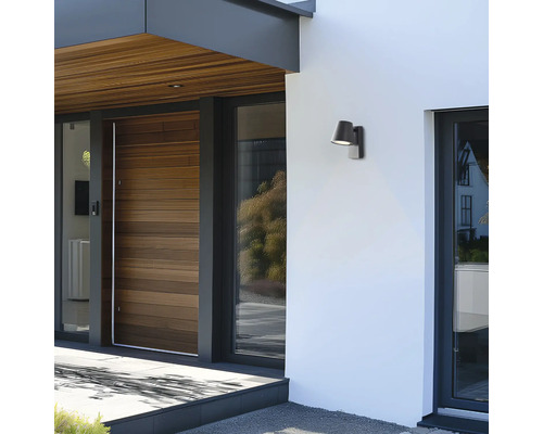 Aussenansicht eines Hauses mit einer Holztür und einer Wandleuchte