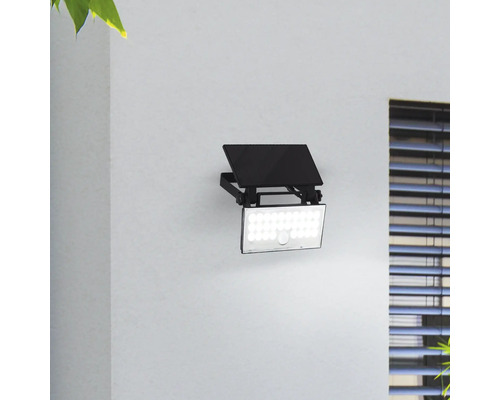 Projecteur d''extérieur LED noir avec détecteur de mouvement monté sur un mur.