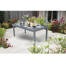 Grauer Gartentisch ausziehbar mit Geschirr und Blumen im Garten