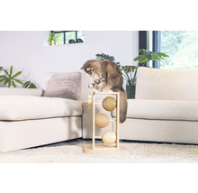 Chat jouant avec un arbre à chat avec trois balles dans un salon
