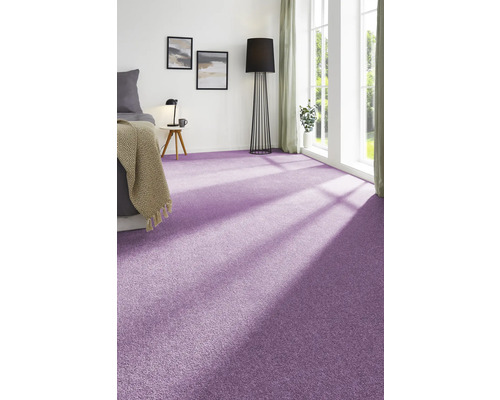 Ein Schlafzimmer mit lila Teppichboden, einem Bett, einem Beistelltisch und einer Stehlampe.